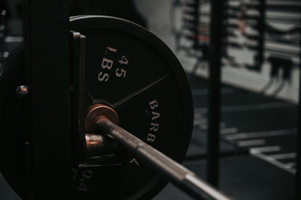 Detailed close-up of a heavy barbell loaded with a 45 lbs weight plate in a gym setting.